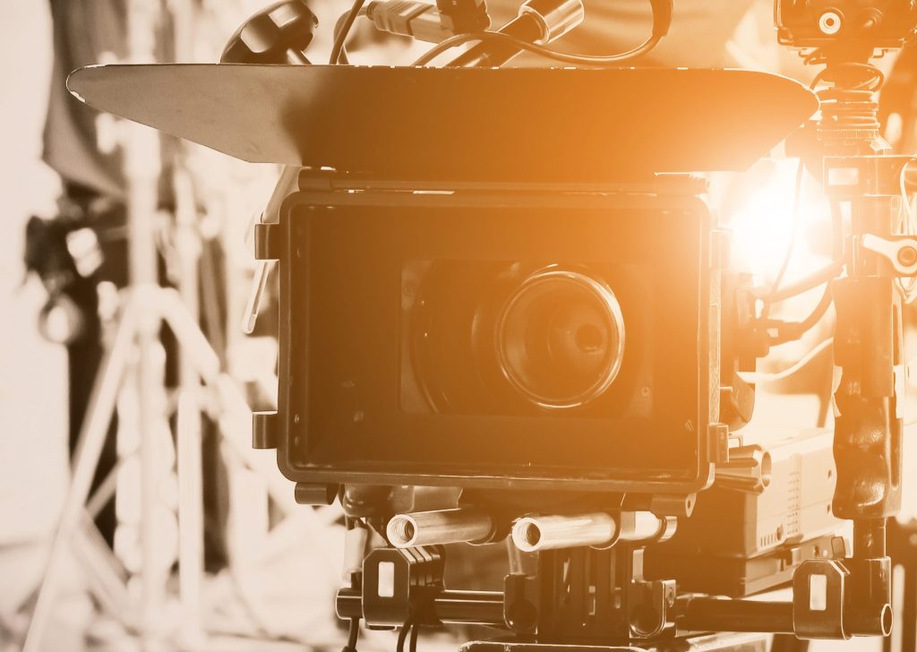 Close-up of a professional video camera setup indoors, capturing high-quality footage.